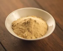 a bowl of brownulated sugar on a wooden table